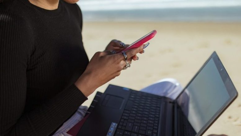 Work from anywhere girl with laptop on beach