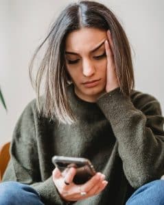 woman saddened by iphone message