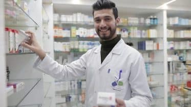 Pharmacist stacking chemist shelves