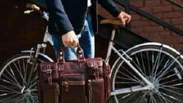 Man with briefcase next to cycle