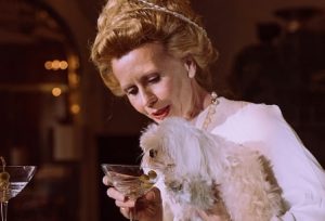 Wealthy woman feeding champagne to poodle