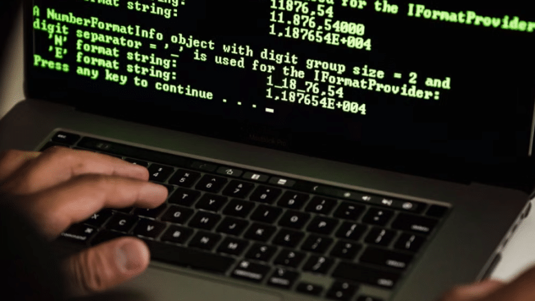 Anonymous hacker at computer screen